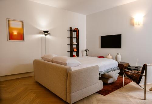 - une chambre avec un lit, un canapé et une télévision dans l'établissement Babylon Marais, à Paris