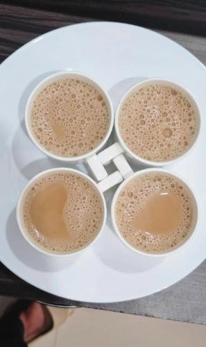vier kopjes koffie op een wit bord bij Karickanattu Nature Resort in Idukki