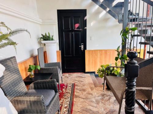 a living room with chairs and a black door at Homestay Thác Liên Khương in Ðưc Trọng
