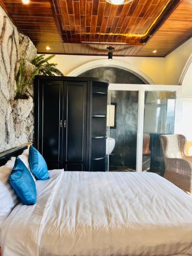 a bedroom with a bed with blue pillows on it at Homestay Thác Liên Khương in Ðưc Trọng