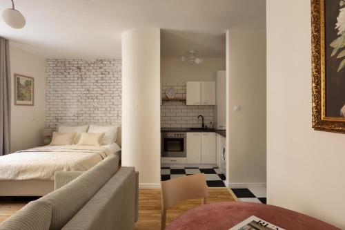 a living room with a bed and a kitchen at Prestigious Main Square Apartment in Kraków