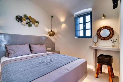 a bedroom with a bed and a window and a mirror at Panoramic Villa in Akrotiri with Stunning Views in Akrotiri