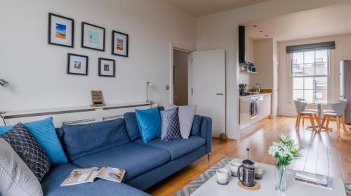 a living room with a blue couch and a table at Channel View Apartments in Deal