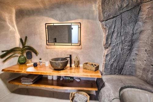 a bathroom with a sink and a mirror on a wall at Panoramic Villa in Akrotiri with Stunning Views in Akrotiri