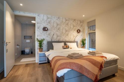 a bedroom with a large bed and a bathroom at Huis te Zeijen in Zeyen