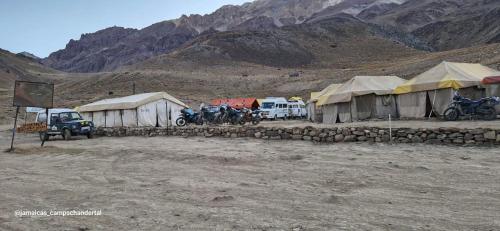 a group of tents and motorcycles parked in a field at Jamaica camp chandertal 2011 in Kalaksar