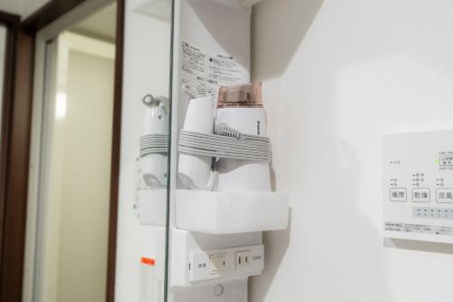 a bathroom with a soap dispenser on a wall at Apartment Hotel KANSO in Kyoto