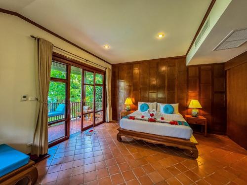 a bedroom with a large bed and a balcony at Baan Thai Lanta Resort in Ko Lanta