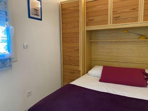 une chambre avec un lit avec un oreiller rouge dessus dans l'établissement Appartement vue mer 3 pièces - Gruissan Ayguades AY110-M04, à Narbonne-Plage