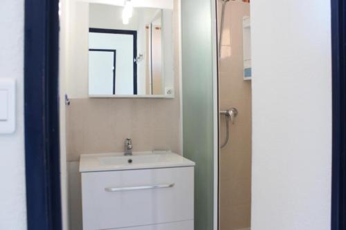 une salle de bain avec un lavabo blanc et un miroir dans l'établissement Appartement vue mer 3 pièces - Gruissan Ayguades AY110-M04, à Narbonne-Plage