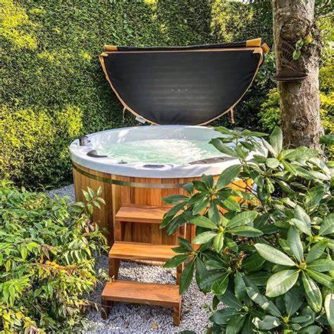 a bath tub in a garden with a tree at Z' Evita in Nieuwpoort