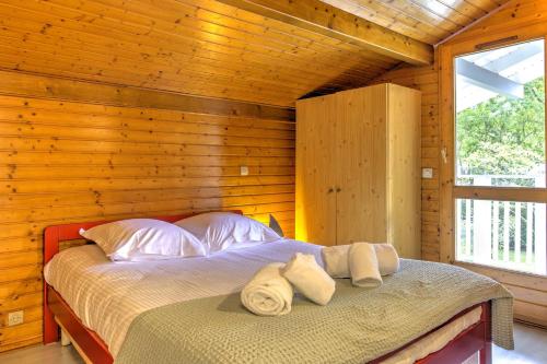 une chambre avec un lit dans une cabane en bois dans l'établissement Le Repaire des Chatons - 15min Dune du Pyla, à La Teste-de-Buch
