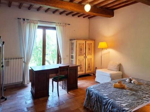 a bedroom with a desk and a bed and a window at IL CASALE DEGLI ULIVI- Splendido casale panoramico con piscina a 30 min da Roma GRA in Calvi dellʼ Umbria