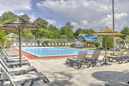 - un groupe de chaises longues et de parasols à côté de la piscine dans l'établissement Le Repaire des Chatons - 15min Dune du Pyla, à La Teste-de-Buch