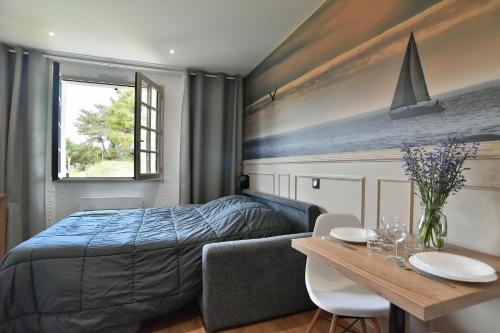 - une chambre avec un lit, une table et une table dans l'établissement Tom 01 - 5min à pied de la Plage, à Fréhel
