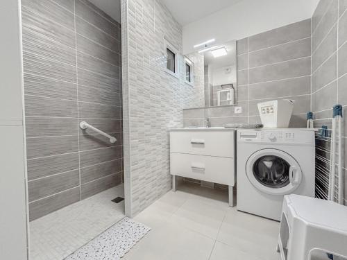 a bathroom with a washing machine and a shower at T3 lumineux avec jardin, parking et piscine in Puget-sur Argens