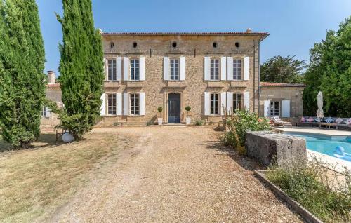 une vieille maison avec une piscine en face de celle-ci dans l'établissement Le Clos Montaugé, à Virsac
