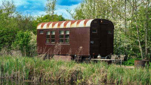 an old train car sitting in the middle of a field at Krusmølle Glamping in Aabenraa