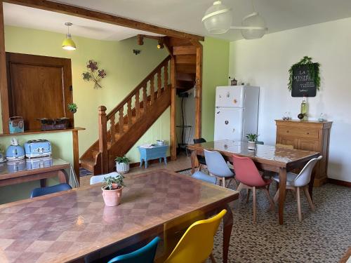 Cette chambre dispose d'une table, de chaises et d'un réfrigérateur. dans l'établissement Gites le Rucher de Kerillis, à Plouguiel