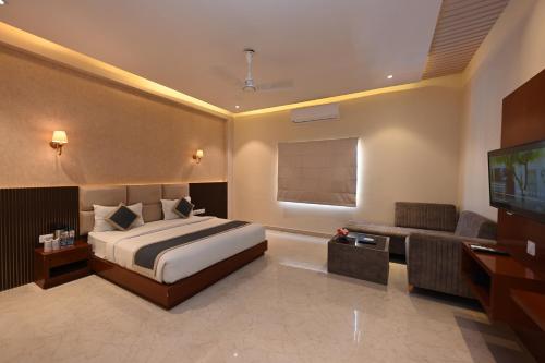 a bedroom with a bed and a flat screen tv at THE GANGA RESORT in Bikaner