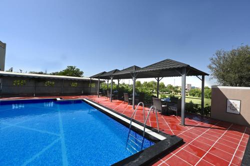 a swimming pool with an umbrella on a house at THE GANGA RESORT in Bikaner