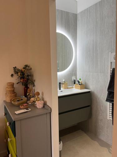 une salle de bain avec un lavabo et un miroir dans l'établissement Jolie maison de 95 m2 avec jardin proche Luberon, à Le Puy-Sainte-Réparade