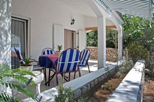 a patio with blue chairs and a table on a porch at Gemütliches, Familienfreundliches Steinhaus in Kolan