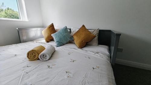 a bed with pillows on it in a bedroom at Entire Cozy home 5 mins from Dublin Airport in Swords