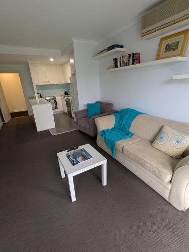 a living room with a couch and a coffee table at The Heart of Glenelg in Glenelg
