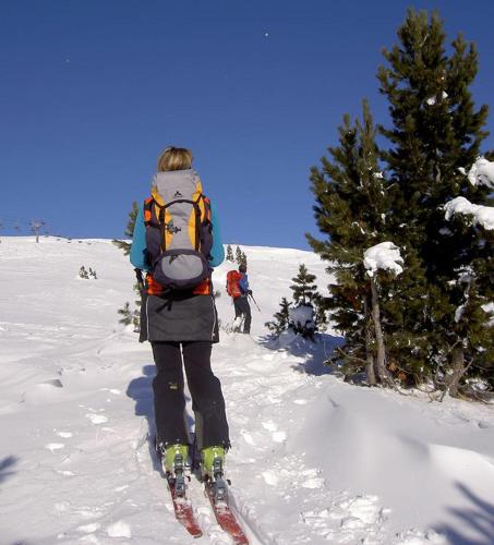 a person on skis in the snow with a backpack at Gemütliches Ferienhaus In Ruhiger Lage in Innerkrems