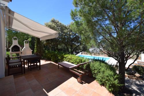 a patio with a table and a white umbrella at Ferienhaus In Mandre Mit Großer Terrasse in Mandre