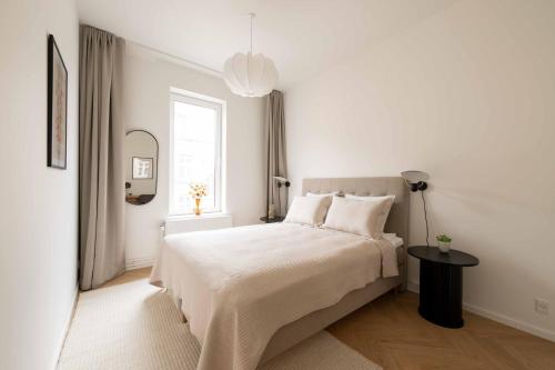 a white bedroom with a bed and a window at Stunning Premium Apartment with Private Rooftop in Copenhagen