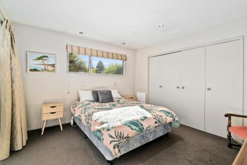 ein Schlafzimmer mit einem Bett und einem Fenster in der Unterkunft Hikuwai Family Retreat - Albert Town Holiday Home in Wanaka