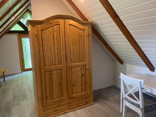 a wooden cabinet in a room with a table at Ferienhaus Im Fachwerkstil Mit Sauna Und Garten in Thomasburg