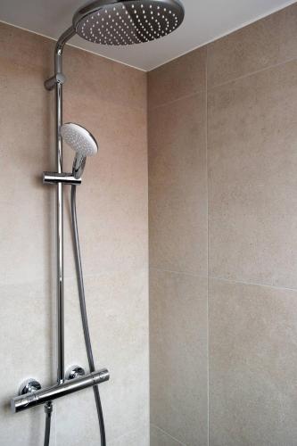 a shower with a shower head in a bathroom at Vakantiehuis de Casembroot in Westkapelle