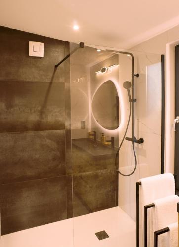 une douche avec une porte vitrée dans une salle de bain dans l'établissement Cottage Umbra Néa, à Montlouis-sur-Loire