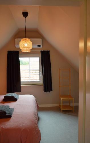 a bedroom with a bed and a window at Vakantiehuis de Casembroot in Westkapelle