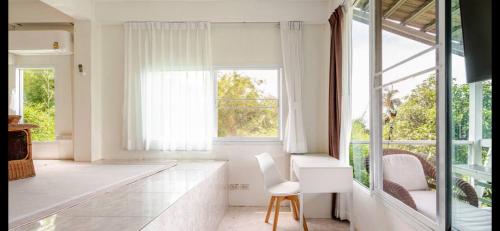 a white kitchen with a chair and a window at Grand view @lamaibeach in Koh Samui 