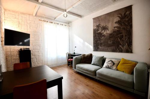 a living room with a couch and a table at Charming T2 on the outskirts of Paris in Saint-Ouen