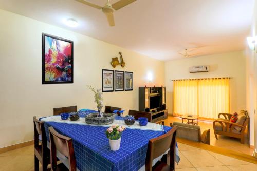 a dining room with a blue table and chairs at Royale Holiday Villa - 4BHK JAQK Holidays in Baga