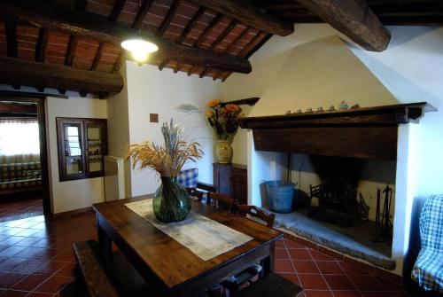 a living room with a table and a fireplace at Rotreiher Urlaub Am Trasimeno See in Pucciarelli