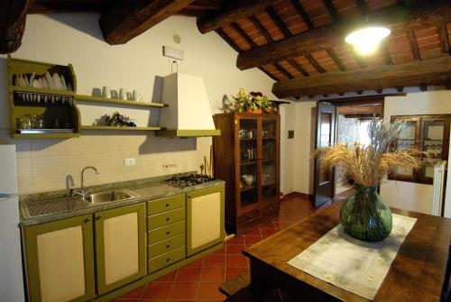 a kitchen with a sink and a vase on a table at Rotreiher Urlaub Am Trasimeno See in Pucciarelli