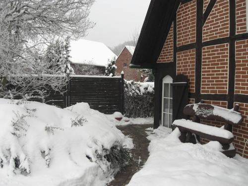 a snow covered yard with a bench in front of a house at Wohnung In Jameln Mit Garten, Grill Und Terrasse in Jameln