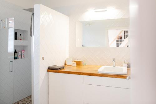 a white bathroom with a sink and a shower at Přibická pohoda na jižní Moravě in Přibice