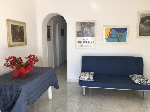 a blue couch and a table with a vase of flowers at Appartamento C in Lipari