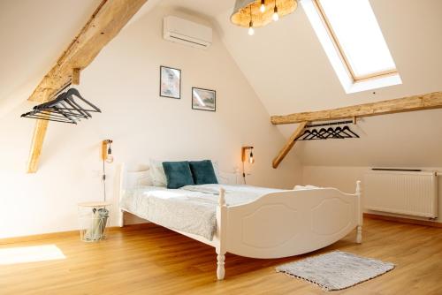 a bedroom with a white bed in a attic at Přibická pohoda na jižní Moravě in Přibice