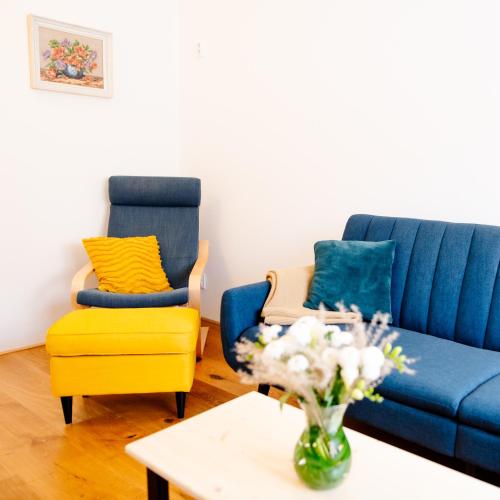 a living room with a blue couch and a yellow chair at Přibická pohoda na jižní Moravě in Přibice