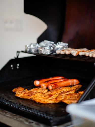 a grill with some hot dogs and some meat at Přibická pohoda na jižní Moravě in Přibice