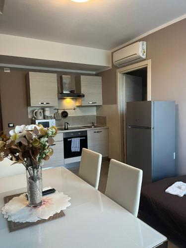 a kitchen with a table with a vase of flowers on it at Appartamenti la Piazzetta vicino a Firenze in Signa