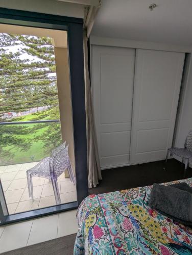 a bedroom with a bed and a window and a chair at The Heart of Glenelg in Glenelg